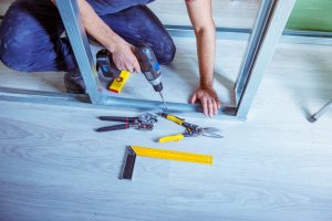 Handwerker bohrt in ein Trockenbauprofil aus Metall