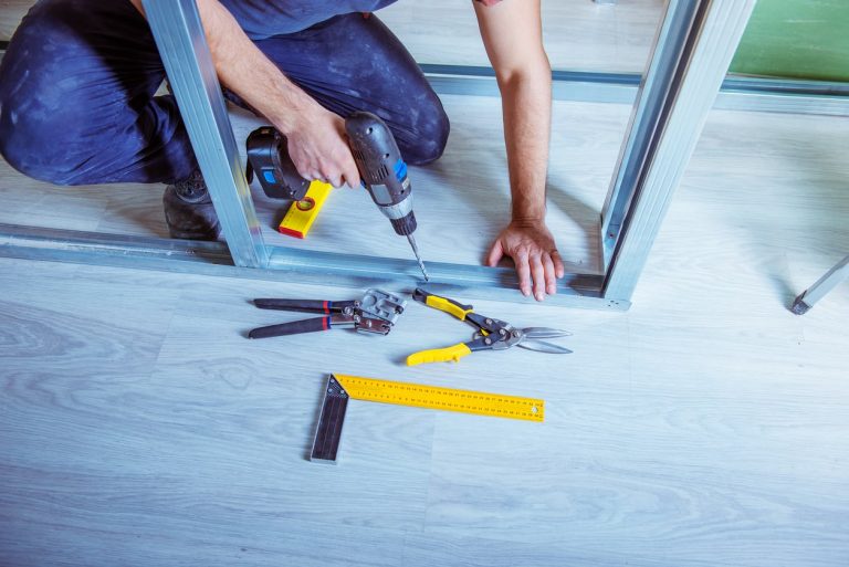 Handwerker bohrt in ein Trockenbauprofil aus Metall