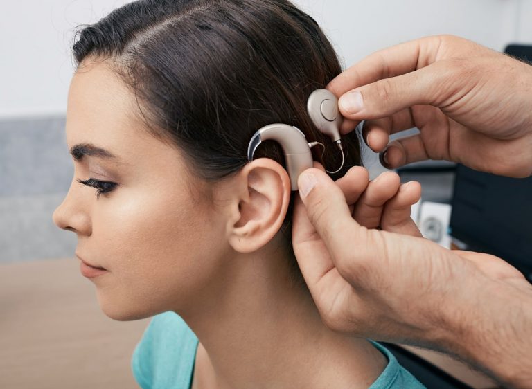 Hörakustiker installiert ein Cochea-Implantat bei einer jungen Frau