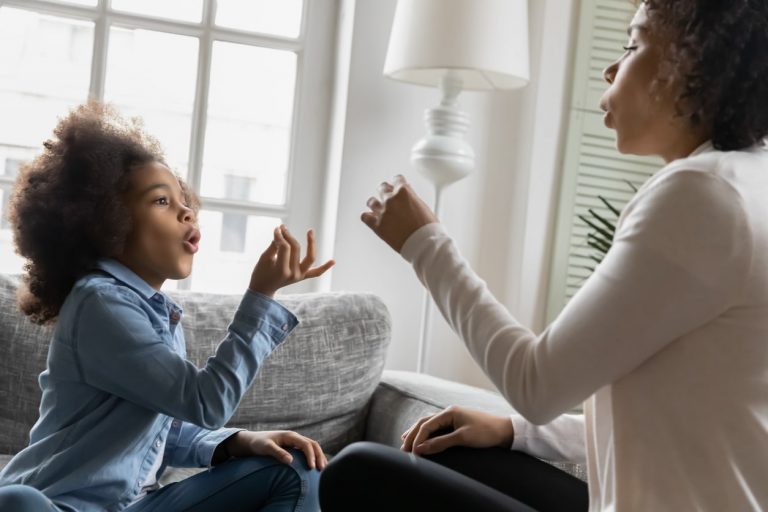 Mutter trainiert Mädchen mit Hand- und Fingergesten zu kommunizieren