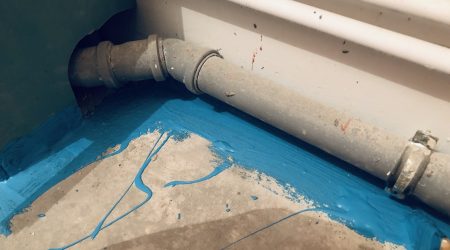 Blauer Dichtstoff zur Bodenabdichtung auf Fugen und Ecken unter Wasserrohren