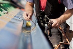 Dachdecker verlötet Dachrinne