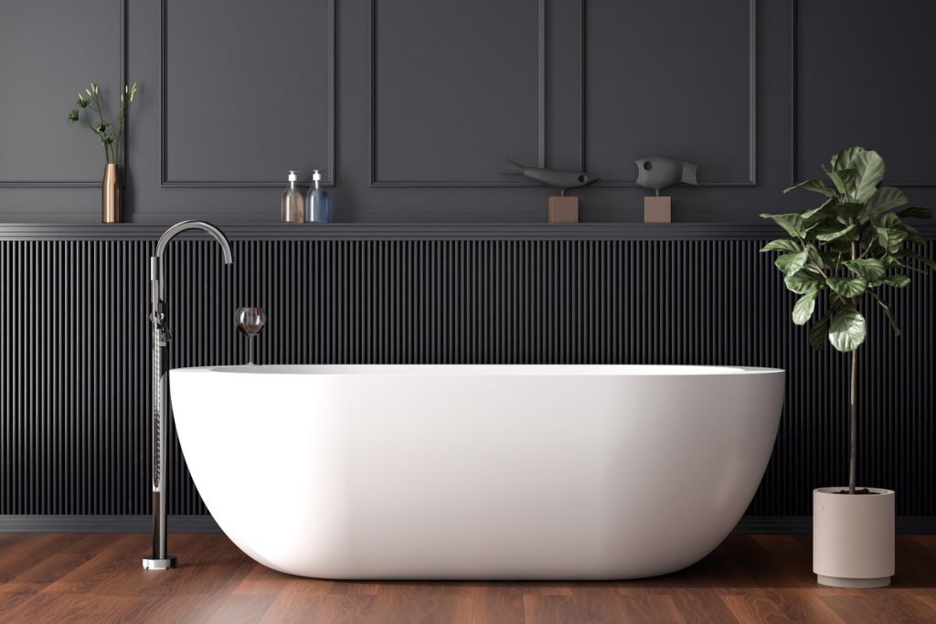 Freistehende weiße Badewanne in einem dunkel getäfelten Badezimmer
