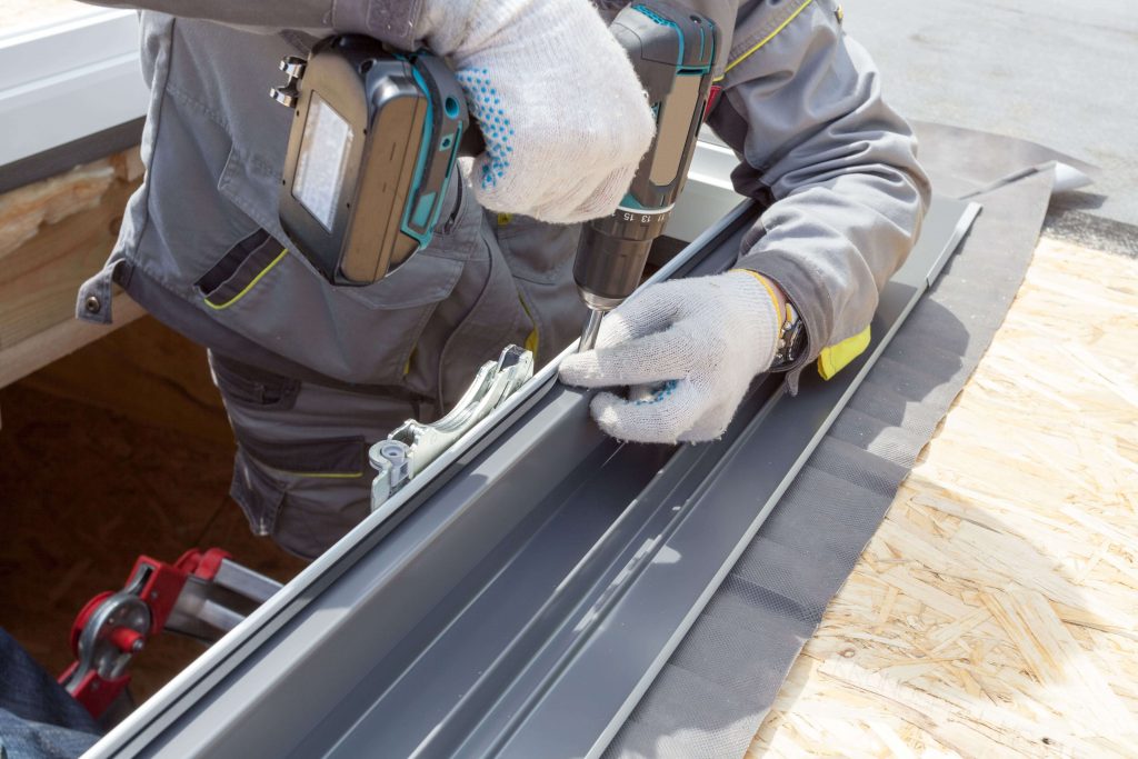 Dachdecker befestigt neuen Fensterrahmen für Dachfenster