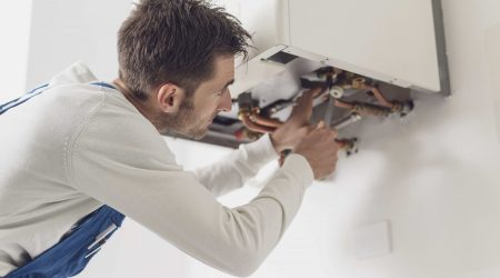 Heizungsmonteur arbeitet am Heizkessel