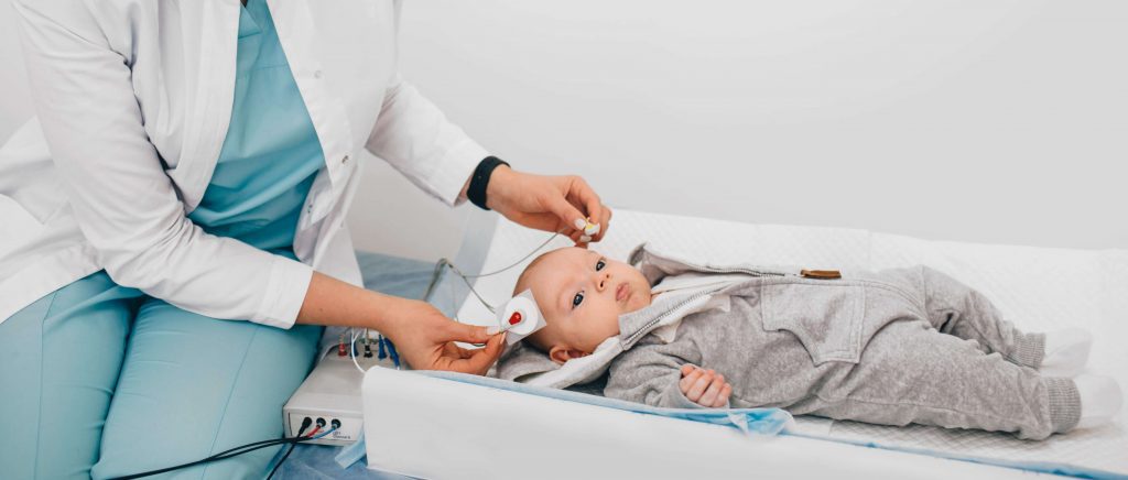 Ärztin und Neugeborenes bei einem Hör Screening