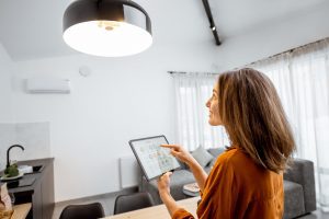 Frau steuert Smart Home Beleuchtung mit einem Tablet