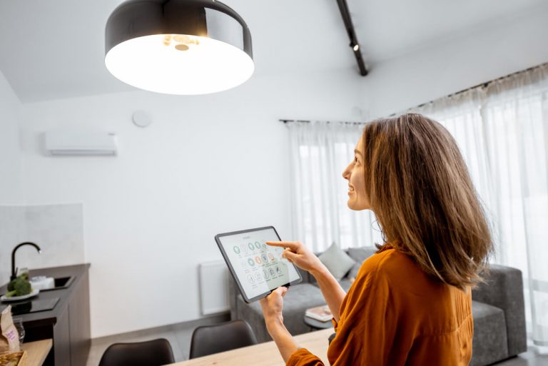 Frau steuert Smart Home Beleuchtung mit einem Tablet