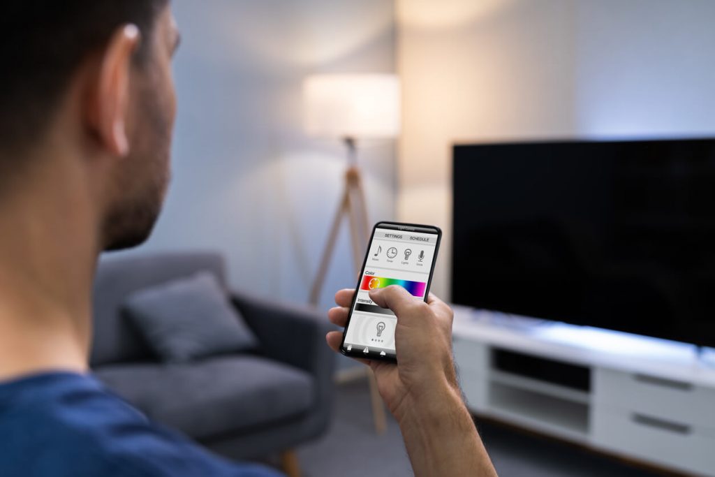 Mann steuert Licht durch App auf seinem Handy