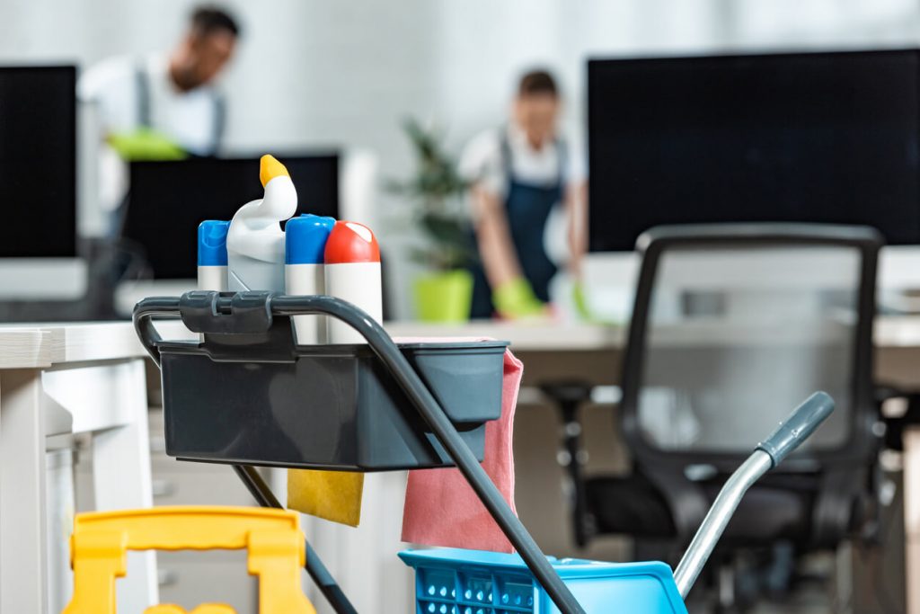 Reinigungswagen mit Putzmitteln in einem Büro mit Facility Managern