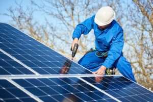 Elektriler installiert Solarmodule auf einem Dach