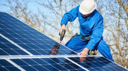 Elektriler installiert Solarmodule auf einem Dach