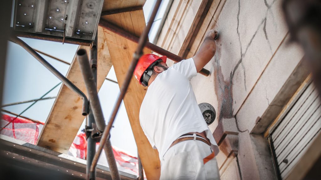 Handwerker arbeitet an einer Hausfassade