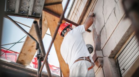 Handwerker arbeitet an einer Hausfassade
