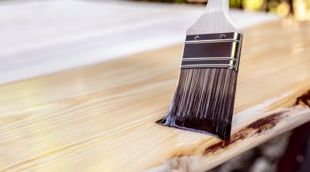 Mit einem Pinsel wird die Grundierung auf das Holz aufgetragen