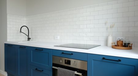 Skandinavische Küche mit weißer Arbeitsplatte und blauen Küchenfronten