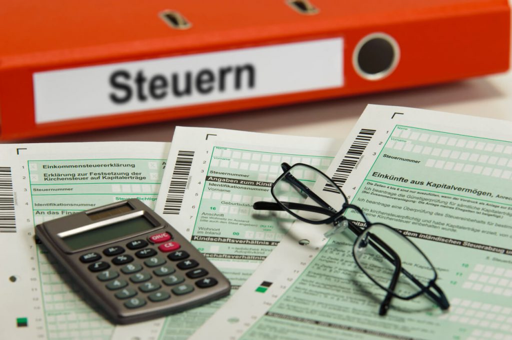 Taschenrechner und Brille auf einer Steuererklärung