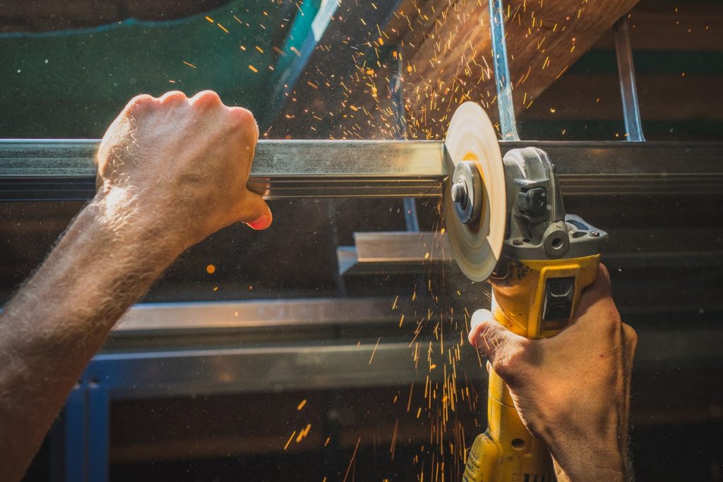 Handwerker schneidet mit einem Winkelschleifer Trockenbauprofile