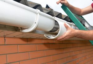 Dachdecker montiert eine Regenrinne an ein Dach