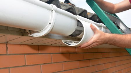 Dachdecker montiert eine Regenrinne an ein Dach
