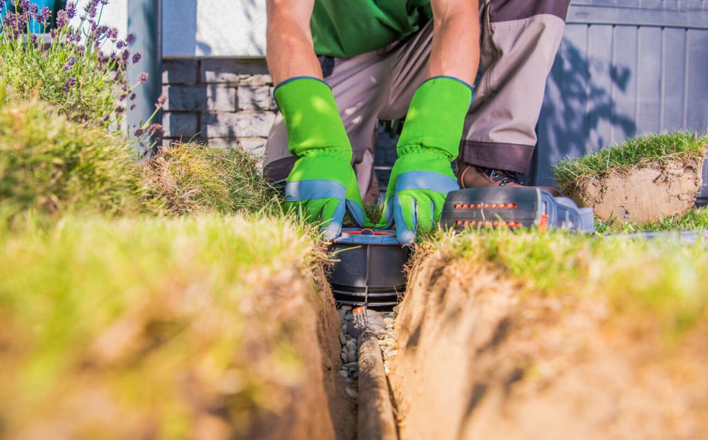 Gärtner baut Garten Bewässerungssystem
