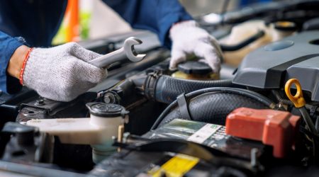 Automechaniker arbeitet an einem Motor eines Autos