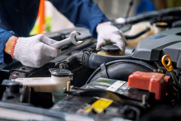 Automechaniker arbeitet an einem Motor eines Autos