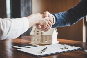 Makler und Hausverkäufer reichen sich die Hand