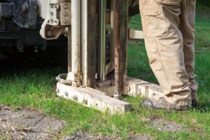 Gutachter nimmt Bodenprobe bei einer Baugrunderkundung