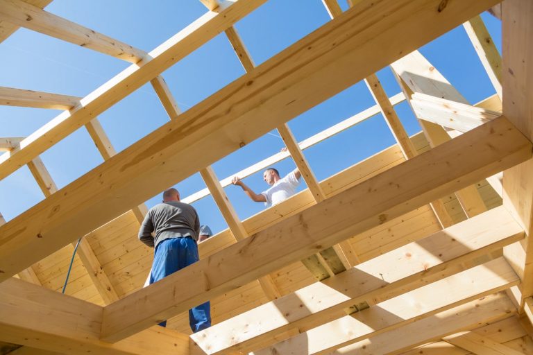 Dachdecker bei der Arbeit an einem Dachstuhl mit Sparren