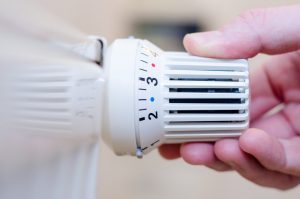 Hand einer einem Heizungsthermostat