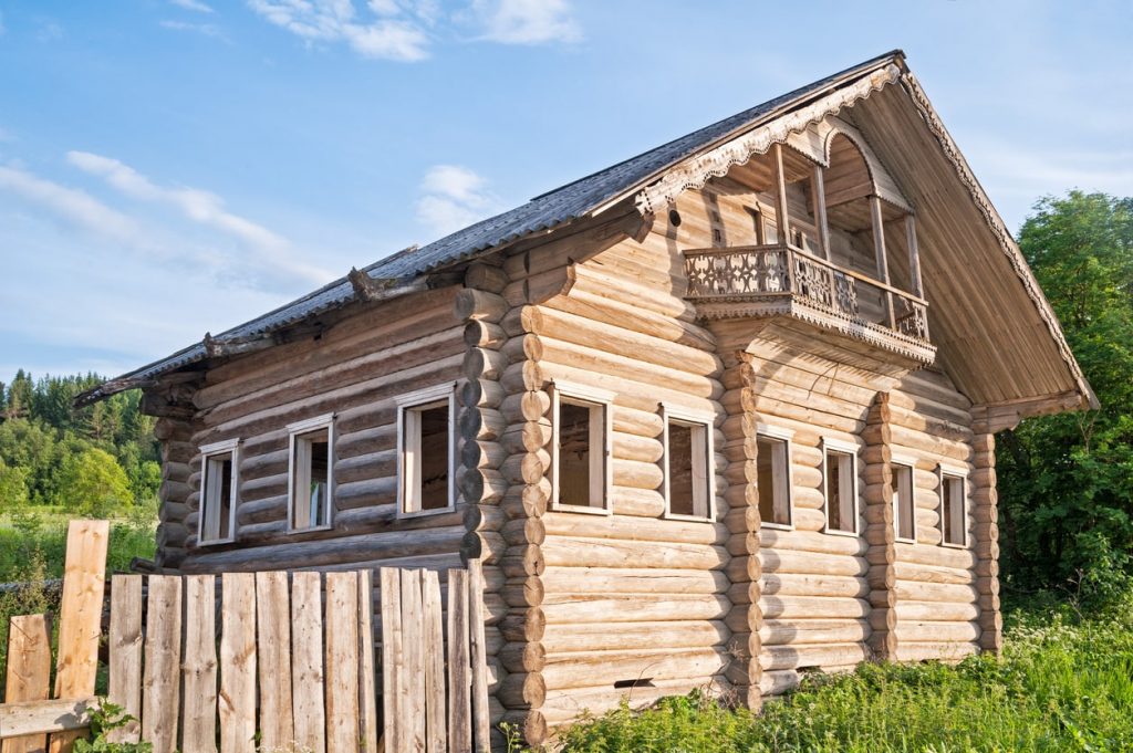 Großes Blockhaus mit Naturstämmen und kleinem Balkon