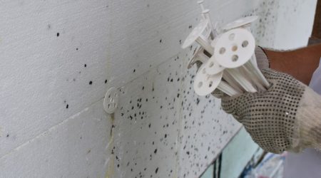 Handwerker mit Dübel für Wärmedämmung in der Hand