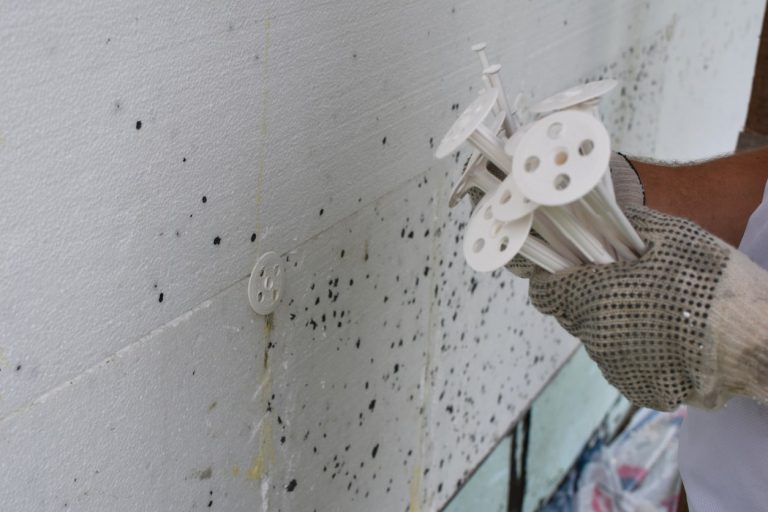 Handwerker mit Dübel für Wärmedämmung in der Hand