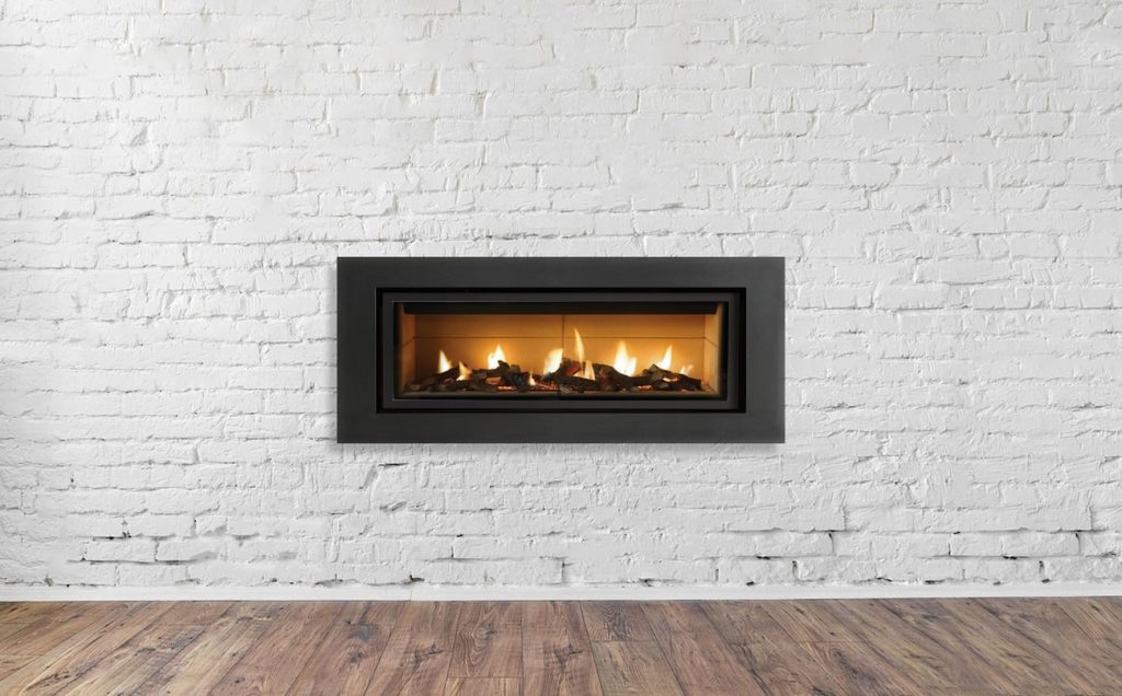 Brennender Gaskamin in einer weißen Wand mit schwarzer Umrandung