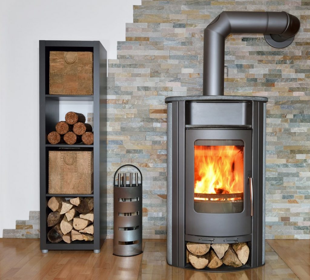 Brennender Kaminofen mit Brennholz