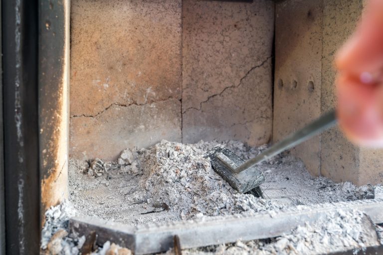 Brennraum eines Ofens mit Schamottsteinen, Ruß und Asche