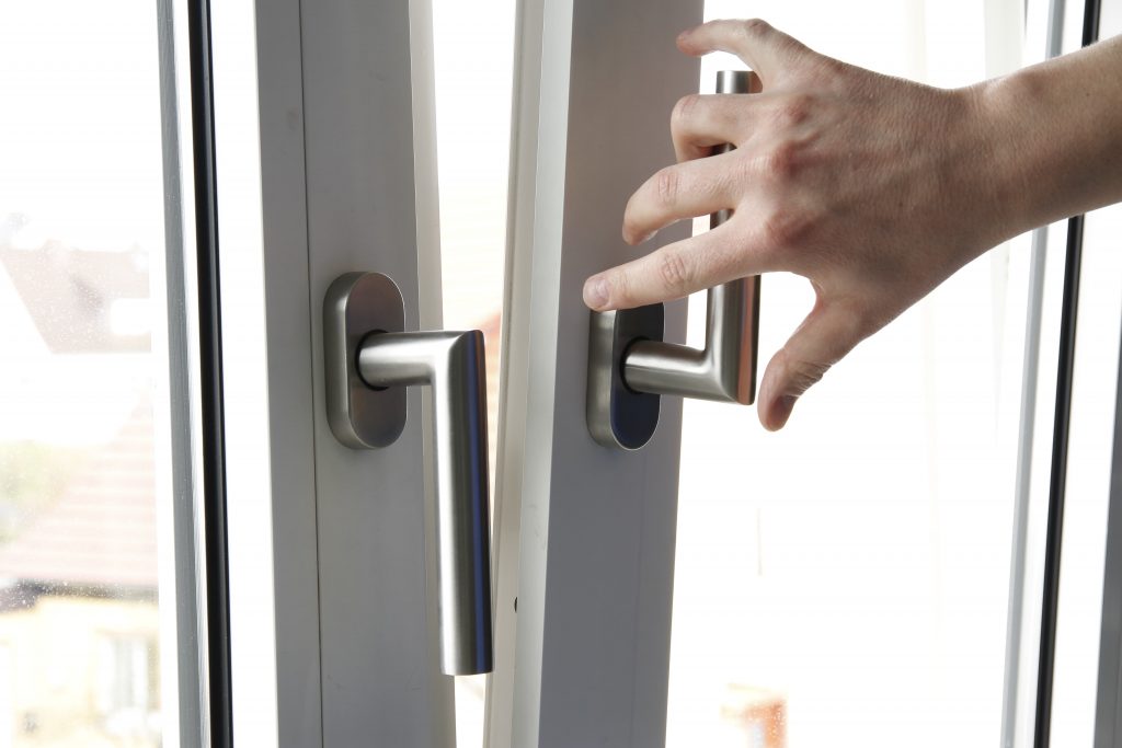 Hand an einem gekippten Dreh-Kipp-Fenster