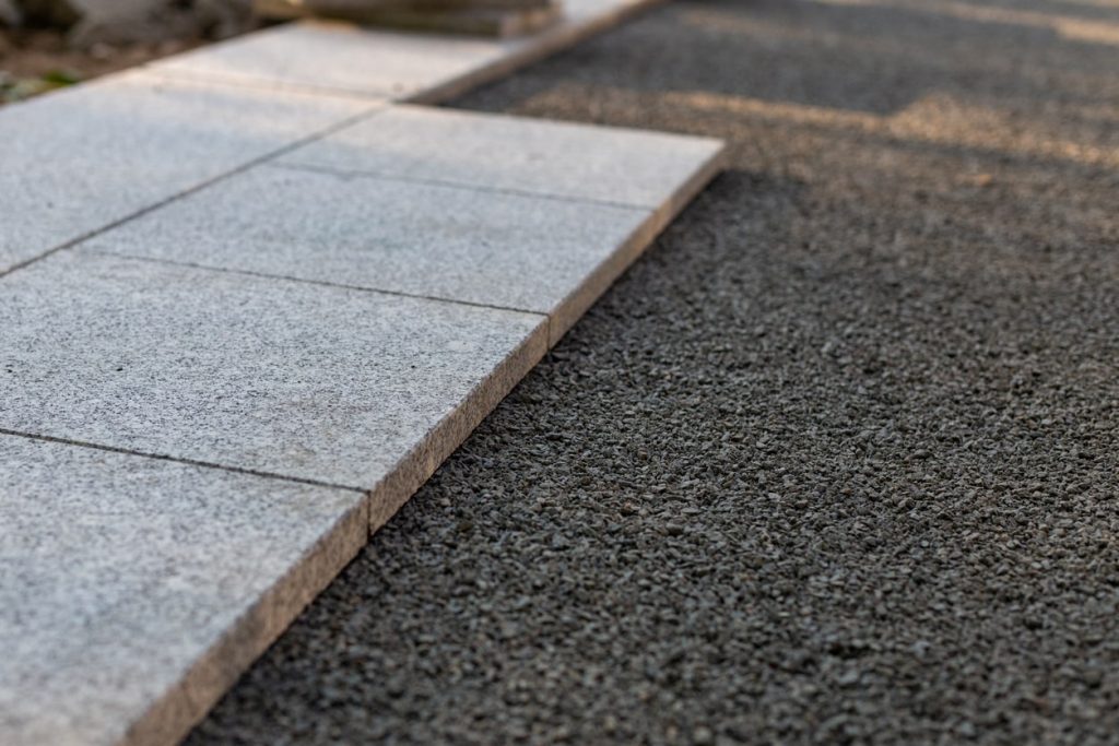 Terrassenplatten einer gepflasterten Terrasse die auf einem Untergrund aus Split verlegt werden