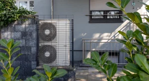 Wärmepumpe als alternatives Heizsystem vor einem Wohnhaus