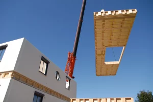 Kran hebt Bauteil für Fertighaus