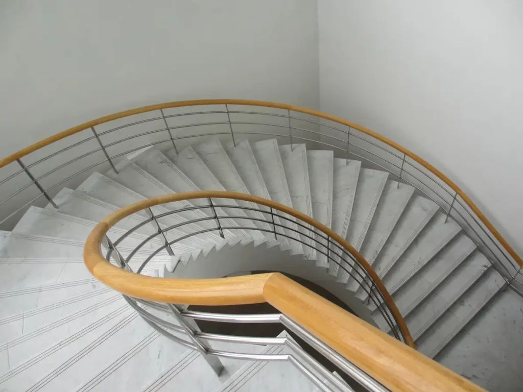 Bogentreppe in einem Hausgang mit Handlauf aus Holz