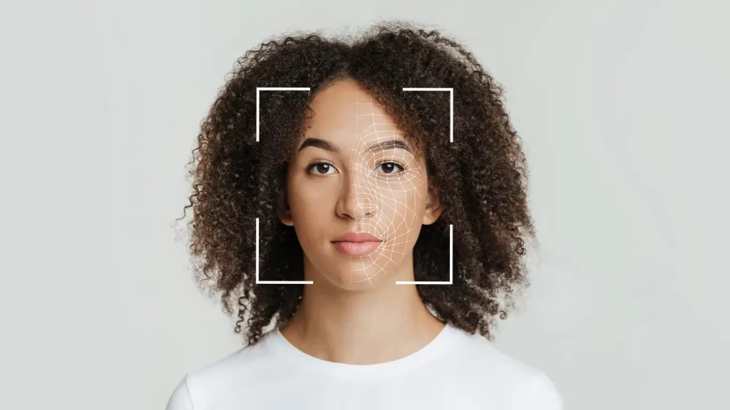 Biometrische Gesichtserkennung einer jungen afroamerikanischen Frau vor einem grauen Hintergrund 