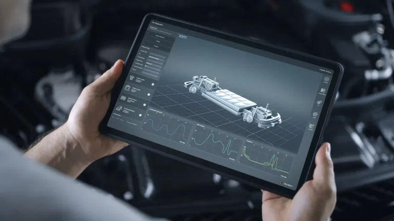 Werkstattmitarbeiter hält ein Tablet in den Händen zur Diagnose von Elektroautobatterien