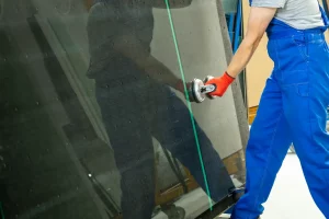 Glaser hebt mit professionellen Saugnäpfen eine Glasscheibe für den Austausch von Fensterscheiben hoch