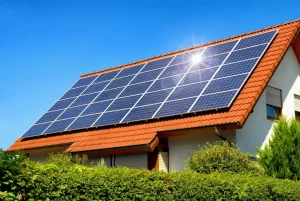 Photovoltaikanalge auf einem Dach von einem Einfamilienhaus mit blauem Himmel im Hintergrund