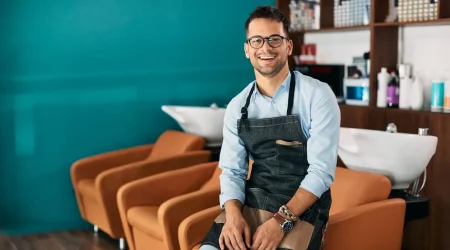 Friseur sitzt in seinem Salon