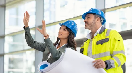 Baubegleiter auf einer Baustelle mit Bauherren im Gespräch
