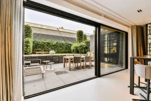 Eine große Hebeschiebetür in einem Wohnzimmer mit Blick auf Terrasse und Garten