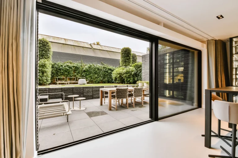 Eine große Hebeschiebetür in einem Wohnzimmer mit Blick auf Terrasse und Garten